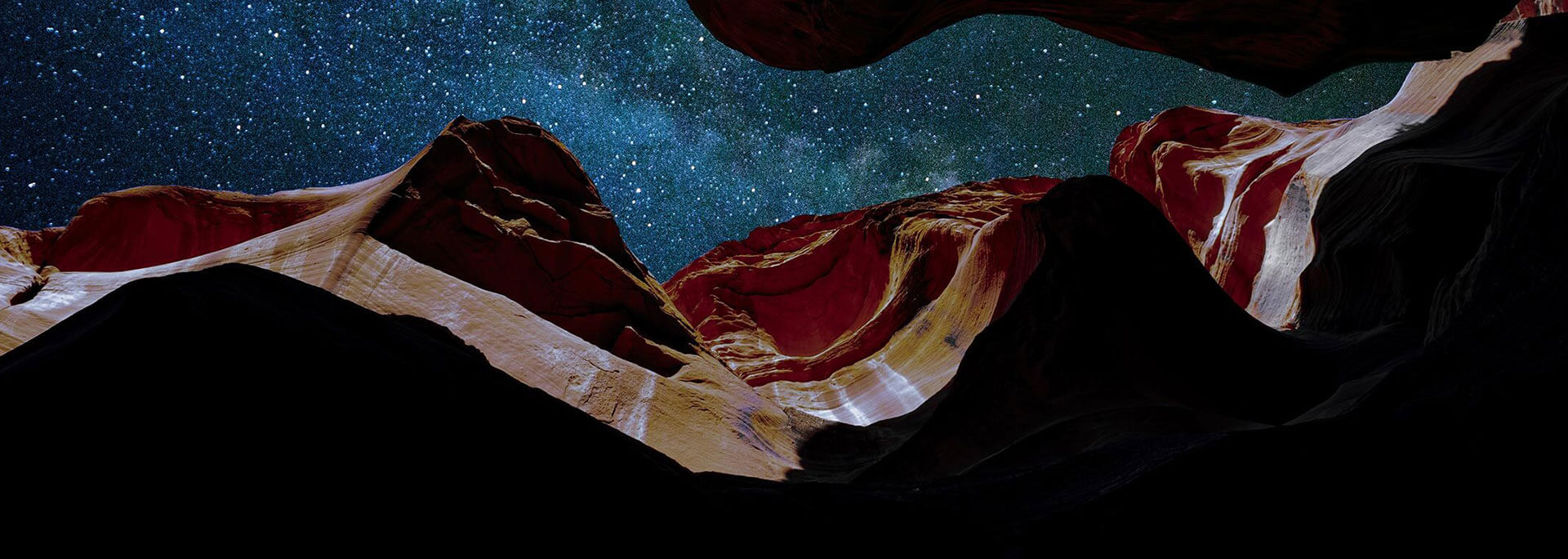 
		Looking up at a star filled night sky from the bottom of a canyon		
